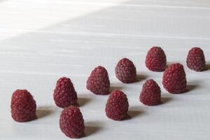 Ripe raspberries on a white wooden background. photo