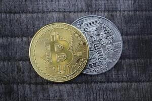 Golden and silver bitcoins on the wooden background. The coins of cryptocurrency. photo