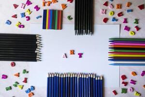 multicolor letras y conjunto de lapices en el mesa. vistoso de madera alfabeto y lapices en un mesa. foto