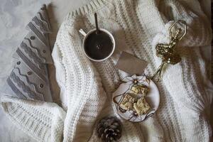 A cup of coffee, woolen sweater and Christmas decorations. Winter still life. photo