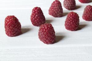 Ripe raspberries on a white wooden background. photo