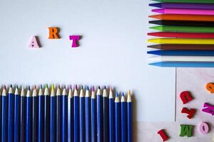 Multicolor letters and set of pencils on the table. Colorful wooden alphabet and pencils on a table. photo