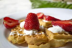 Ripe strawberry on waffles close up. Beautiful and tasty breakfast. photo