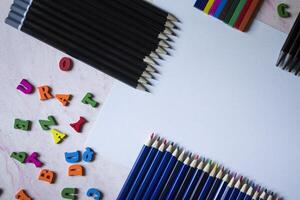 Multicolor letters and set of pencils on the table. Colorful wooden alphabet and pencils on a table. photo