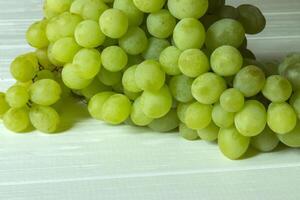 Ripe grapes on a white wooden background. photo