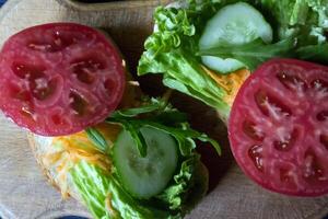 The sandwiches with vegetables on a board. Vegetarian food. Ingredients for cooking on the table. photo