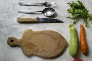 ingredientes para Cocinando ensalada, y cuchillería en un cocina mesa. foto