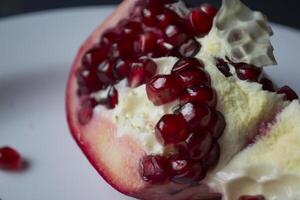 Pomegranate on a white plate. Close up. photo