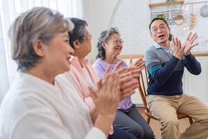 senior females and male sitting on bench. older people are listening and enjoy meeting focus group at living room. Joyful carefree retired senior friends enjoying relaxation at nearly home. photo