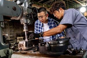 asiático trabajador en producción planta perforación a máquina. profesional trabajador cerca perforación máquina en fábrica. refinamiento metal trabajando interno acero superficie en torno amoladora máquina con volador chispas. foto