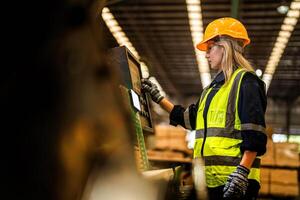 fábrica ingeniero mujer en pie confidente a controlar panel cambiar. trabajador trabajos a pesado máquina a industria fábrica. trabajador comprobación madera de crudo madera material. inteligente industria trabajador operando. foto