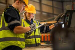 actoria ingeniero trabajadores en pie a controlar panel cambiar. personas trabajos a pesado máquina a industria fábrica. con maquinaria equipo planta tecnología. inteligente industria trabajador operando. foto