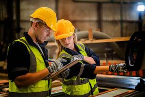 actoria ingeniero trabajadores en pie a controlar panel cambiar. personas trabajos a pesado máquina a industria fábrica. con maquinaria equipo planta tecnología. inteligente industria trabajador operando. foto