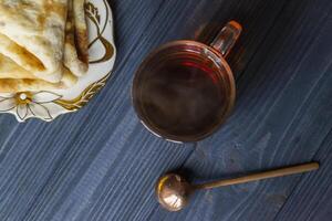 A cup of tea and cakes on a rustic table. Cozy winter time. photo