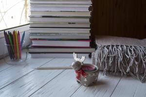 Cozy desktop with books, candle light and beautiful decorations. photo