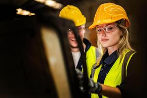 Factory engineer woman standing confidence to control panel switch. Worker works at heavy machine at industry factory. with machinery equipment plant technology. smart industry worker operating. photo