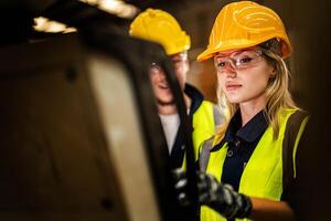 Factory engineer woman standing confidence to control panel switch. Worker works at heavy machine at industry factory. with machinery equipment plant technology. smart industry worker operating. photo