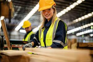 mujer limpieza madera madera en oscuro almacén industria. equipo trabajador carpintero vistiendo la seguridad uniforme y difícil sombrero trabajando y comprobación el calidad de de madera productos a taller fabricación. foto