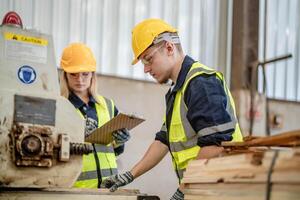 worker carpenters working in machines to cut wood timber. man and woman are crafting with wood in a workshop. two craftsmen or handymen working with carpenter tools or electric machines. photo