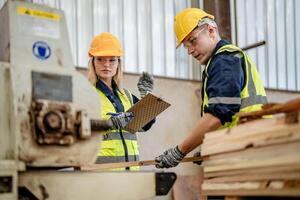 worker carpenters working in machines to cut wood timber. man and woman are crafting with wood in a workshop. two craftsmen or handymen working with carpenter tools or electric machines. photo