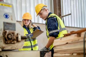 worker carpenters working in machines to cut wood timber. man and woman are crafting with wood in a workshop. two craftsmen or handymen working with carpenter tools or electric machines. photo