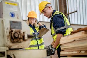 worker carpenters working in machines to cut wood timber. man and woman are crafting with wood in a workshop. two craftsmen or handymen working with carpenter tools or electric machines. photo