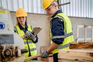 worker carpenters working in machines to cut wood timber. man and woman are crafting with wood in a workshop. two craftsmen or handymen working with carpenter tools or electric machines. photo