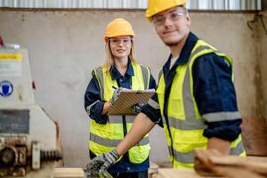 worker carpenters working in machines to cut wood timber. man and woman are crafting with wood in a workshop. two craftsmen or handymen working with carpenter tools or electric machines. photo