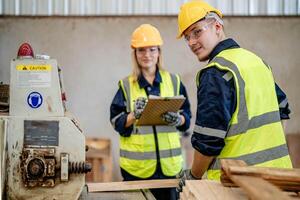 worker carpenters working in machines to cut wood timber. man and woman are crafting with wood in a workshop. two craftsmen or handymen working with carpenter tools or electric machines. photo