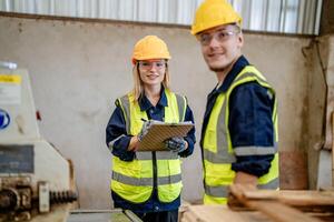 worker carpenters working in machines to cut wood timber. man and woman are crafting with wood in a workshop. two craftsmen or handymen working with carpenter tools or electric machines. photo