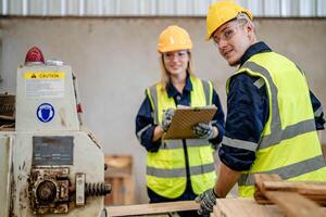 worker carpenters working in machines to cut wood timber. man and woman are crafting with wood in a workshop. two craftsmen or handymen working with carpenter tools or electric machines. photo