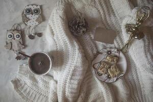 A cup of coffee, woolen sweater and Christmas decorations. Winter still life. photo