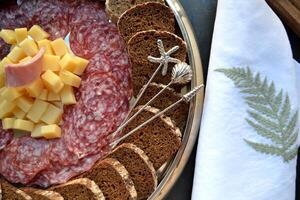 The sliced sausages and cheese on a kitchen table. photo