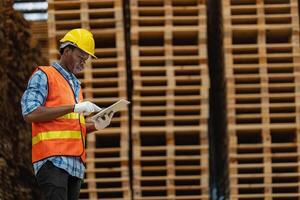 africano trabajadores hombre Ingenieria caminando y inspeccionando con trabajando suite vestir y mano guante en madera madera depósito. concepto de inteligente industria trabajador operando. madera suerte Produce madera paladar. foto