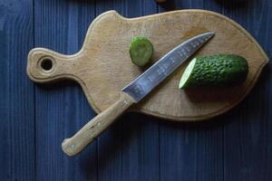 Sliced cucumber on the board with other ingredients for cooking. photo