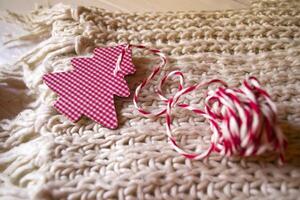 Christmas decorations on the knitted plaid. A toy in a form of christmas tree. photo