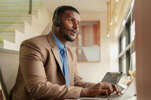 Customer Support Call Center Operator Or Receptionist. customer service and man consultant talking while doing a consultation online. African operator male telemarketing agent on a laptop in office photo