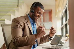 cliente apoyo llamada centrar operador o recepcionista. cliente Servicio y hombre consultor hablando mientras haciendo un consulta en línea. africano operador masculino telemarketing agente en un ordenador portátil en oficina foto