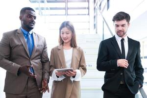 Business people shaking hands. finishing up a meeting. team of business people walk in rush hour at indoor pedestrian stairs and talk together. concept negotiations in feeling successful and happy. photo