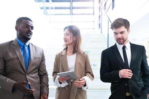 Business people shaking hands. finishing up a meeting. team of business people walk in rush hour at indoor pedestrian stairs and talk together. concept negotiations in feeling successful and happy. photo