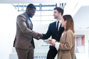 Business people shaking hands. finishing up a meeting. team of business people walk in rush hour at indoor pedestrian stairs and talk together. concept negotiations in feeling successful and happy. photo