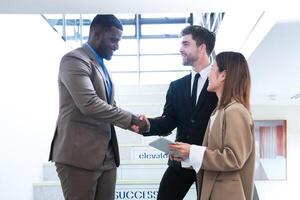 Business people shaking hands. finishing up a meeting. team of business people walk in rush hour at indoor pedestrian stairs and talk together. concept negotiations in feeling successful and happy. photo