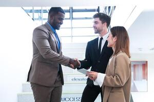 Business people shaking hands. finishing up a meeting. team of business people walk in rush hour at indoor pedestrian stairs and talk together. concept negotiations in feeling successful and happy. photo