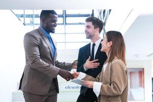 Business people shaking hands. finishing up a meeting. team of business people walk in rush hour at indoor pedestrian stairs and talk together. concept negotiations in feeling successful and happy. photo