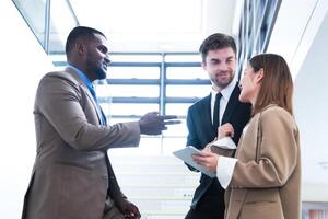 Business people shaking hands. finishing up a meeting. team of business people walk in rush hour at indoor pedestrian stairs and talk together. concept negotiations in feeling successful and happy. photo