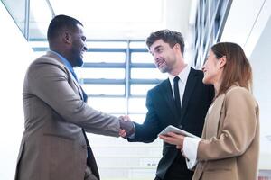 Business people shaking hands. finishing up a meeting. team of business people walk in rush hour at indoor pedestrian stairs and talk together. concept negotiations in feeling successful and happy. photo