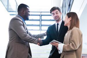 Business people shaking hands. finishing up a meeting. team of business people walk in rush hour at indoor pedestrian stairs and talk together. concept negotiations in feeling successful and happy. photo