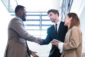 Business people shaking hands. finishing up a meeting. team of business people walk in rush hour at indoor pedestrian stairs and talk together. concept negotiations in feeling successful and happy. photo