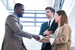 Business people shaking hands. finishing up a meeting. team of business people walk in rush hour at indoor pedestrian stairs and talk together. concept negotiations in feeling successful and happy. photo