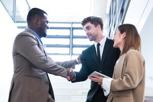 Business people shaking hands. finishing up a meeting. team of business people walk in rush hour at indoor pedestrian stairs and talk together. concept negotiations in feeling successful and happy. photo